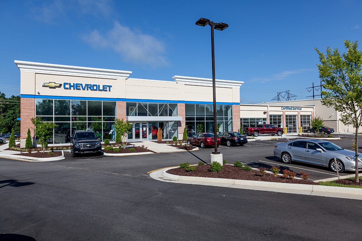 Exterior of a Chevrolet dealership with parked cars and clear blue sky