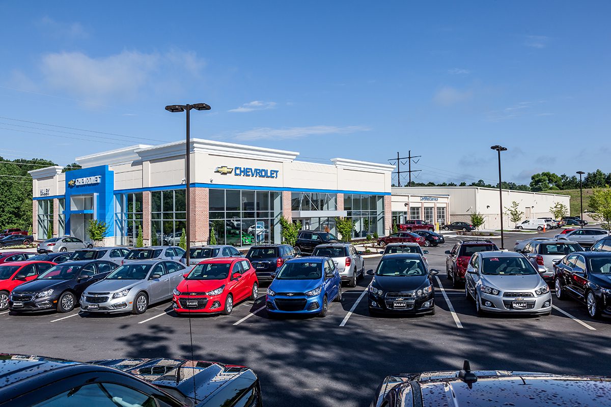 A Chevrolet dealership with a display of new cars in the parking lot