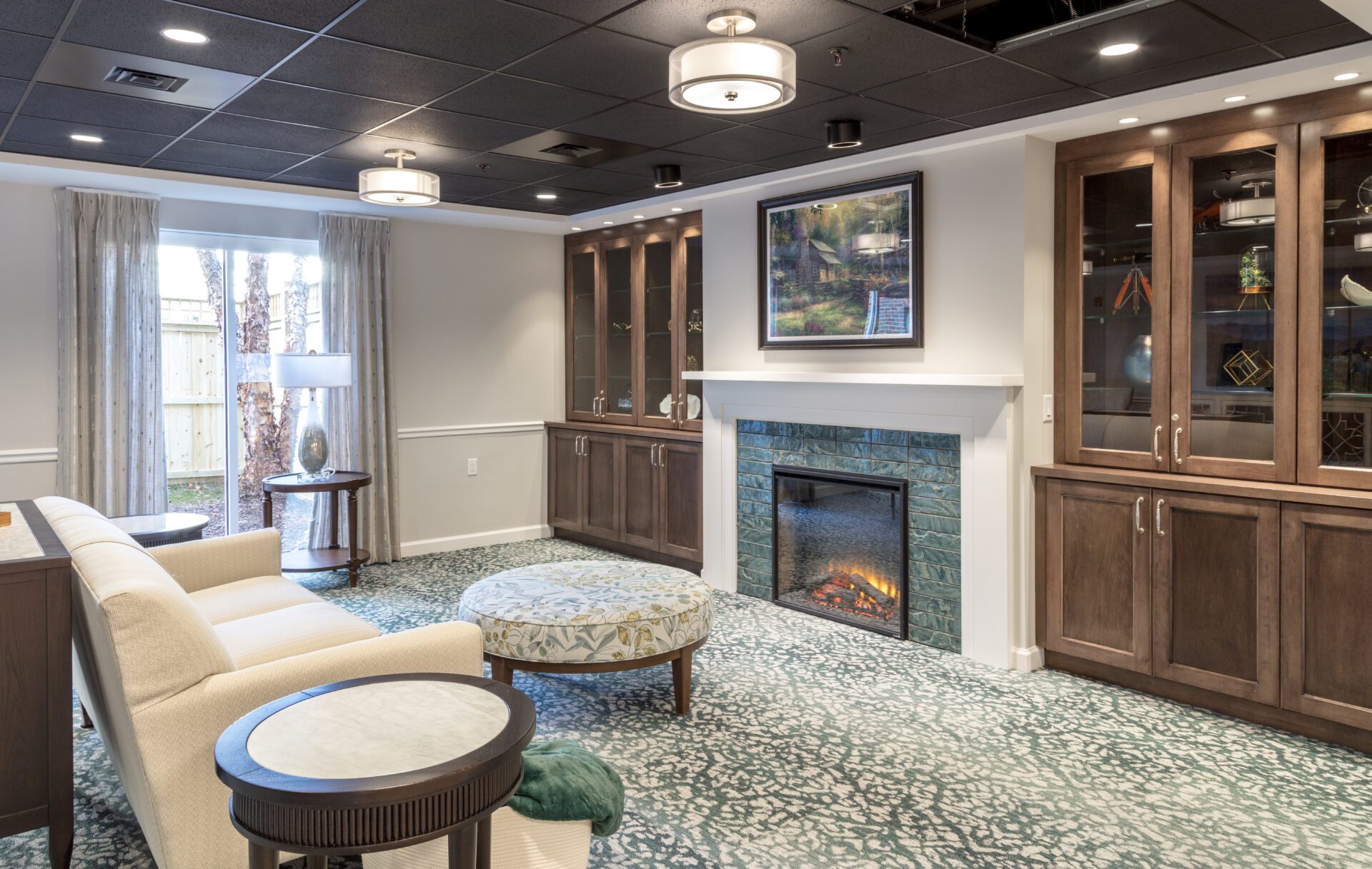 Elegant living space with a fireplace, seating area, and glass cabinet displays