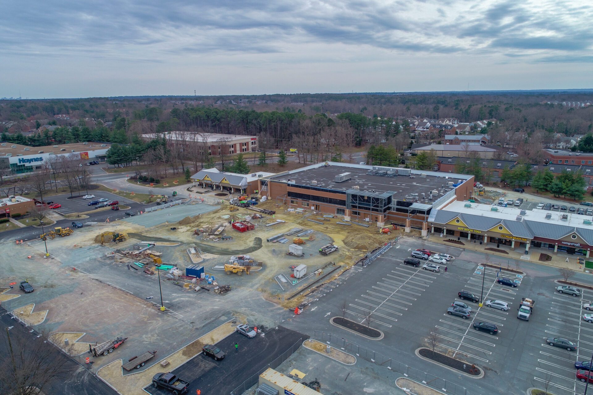 Aerial view of a construction site near a parking lot and surrounding buildings