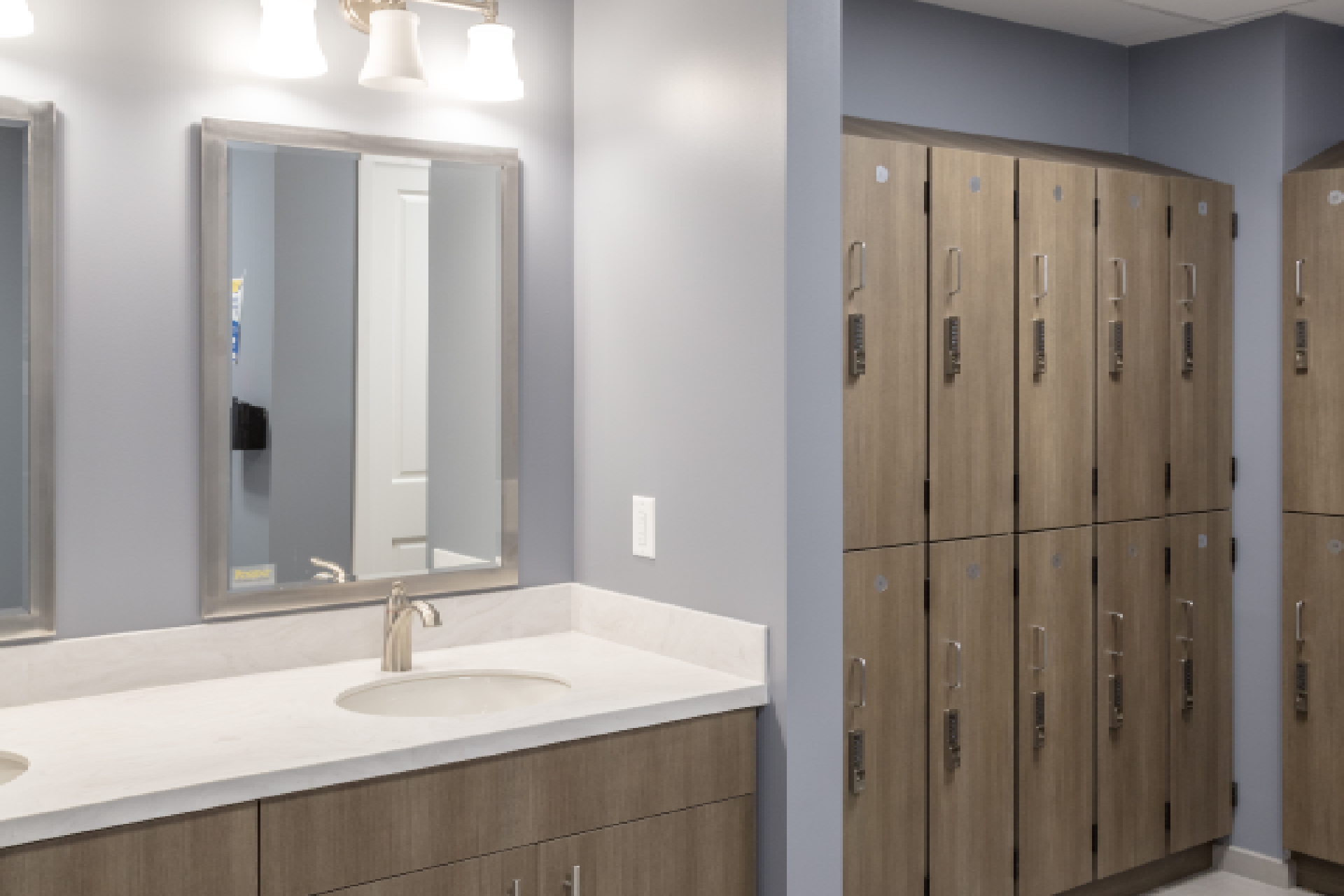 Modern bathroom with dual sink vanity and row of wooden lockers